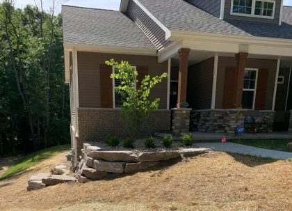 Create mocha ledge rock retaining wall in Brighton, Michigan, install sprinkler system and over seed